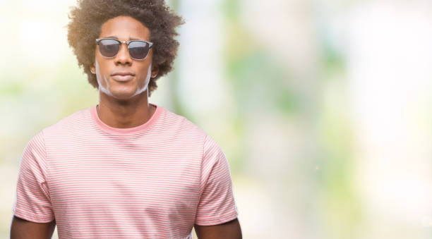 istock Afro american man wearing sunglasses over isolated background with serious expression on face. Simple and natural looking at the camera. 1079803018