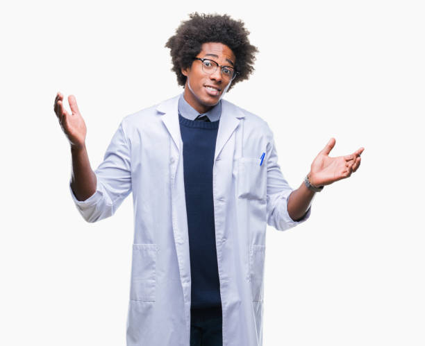 afro amerikansk läkare vetenskapsman mannen över isolerade bakgrund aningslös och förvirrade uttryck med armarna och händerna upp. tvekan koncept. - doctors talking confused bildbanksfoton och bilder