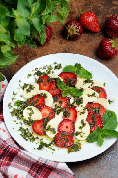 istock Light snack caprese with strawberries and mozzarella dressed   mint pesto 1079819392