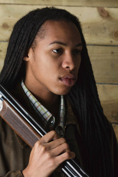 istock Caribbean man with dreadlocks and a shotgun 1079821412