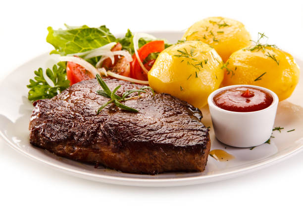 istock Grilled beefsteak, boiled potatoes and vegetables on white background 1079826884