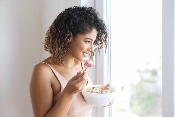 istock Young woman eating muslie 1079832122