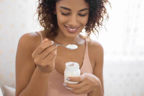 bella mujer comiendo yogur ecológico - tasting women eating expressing positivity fotografías e imágenes de stock