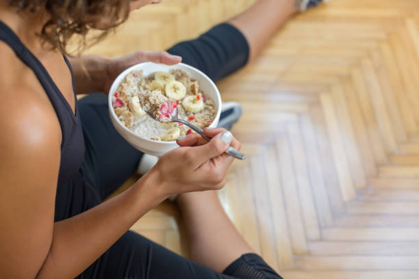 Young woman eating a oatmeal after a workout Young woman eating a oatmeal after a workout breakfast cereal photos stock pictures, royalty-free photos & images