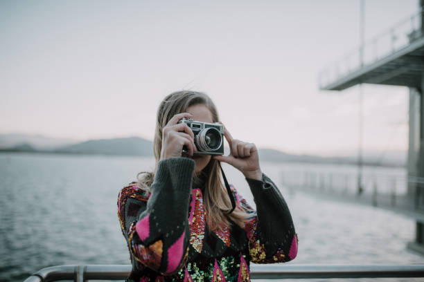 istock Young woman using a vintage camera 1079839180