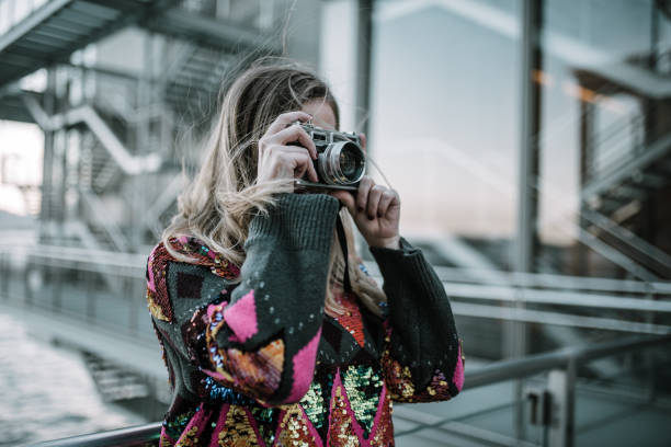 istock Young woman using a vintage camera 1079839288