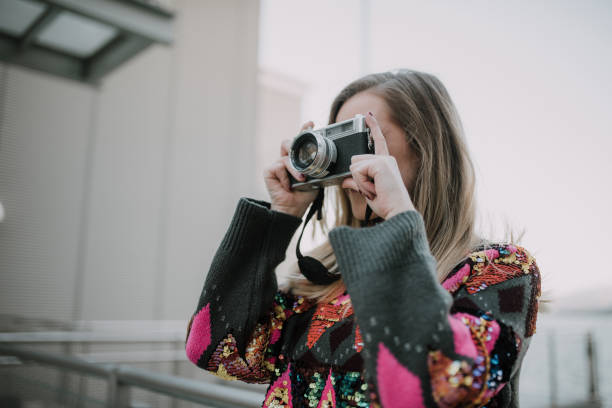 istock Young woman using a vintage camera 1079839324
