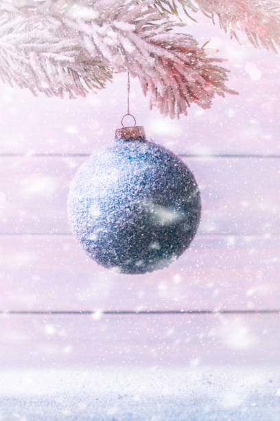 istock Christmas ball on Xmas tree over wooden background in snow fall. 1079841168