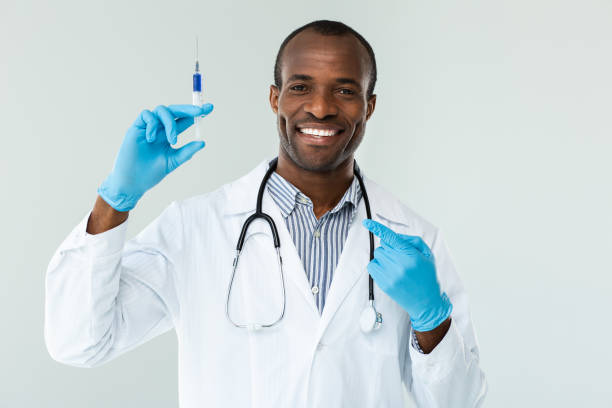 istock Joyful experienced doctor holding a syringe against white background 1079852534