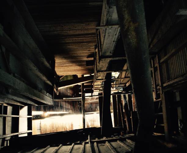 istock Old wooden shaft in old grain elevator, low angle, illuminated, forming abstract, textured, patterned, background in color. 1079859480