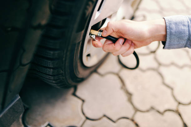 Close up of man pumping tire on his car. Close up of man pumping tire on his car. air pump stock pictures, royalty-free photos & images