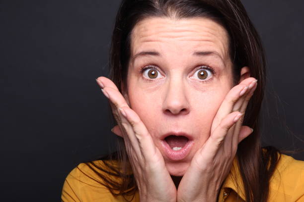 Caucasian woman with brown hair in front of a colored background