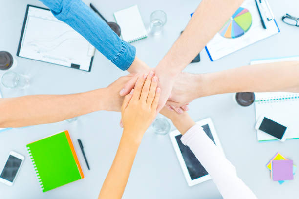 istock The six students hold hands at the desktop. view from above 1079900942