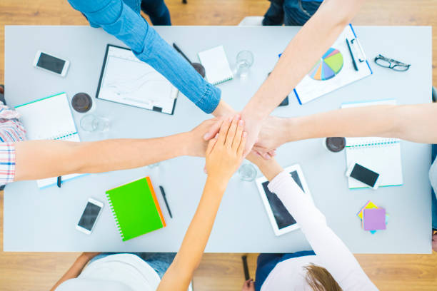 istock The six students hold hands at the desktop. view from above 1079900950