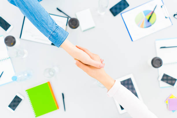 istock The two people handshake at the desktop. view from above 1079901124
