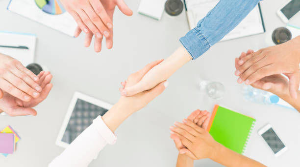 istock The six people handshake and applause at the desktop. view from above 1079901154