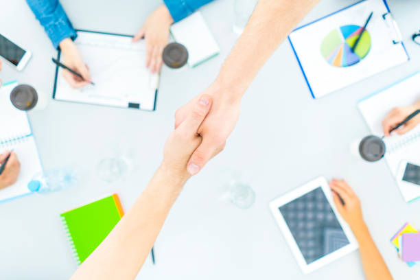 istock The two people handshake near the desktop. view from above 1079901190