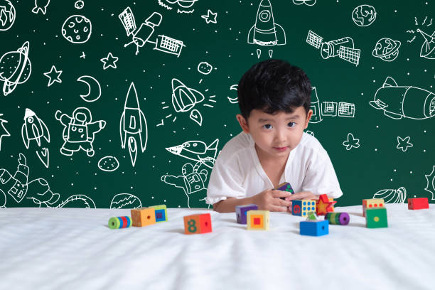 istock Asian kid learning by playing with his imagination about science and space adventure, hand drawn on the green chalkboard, education back to school and discovery concept. 1079904344