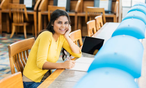 istock Young Hispanic woman in library, studying 1079918174