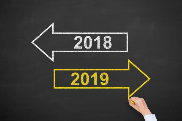 istock Human Hand Drawing Old Year or New Year 2019 on Chalkboard Background 1079930690