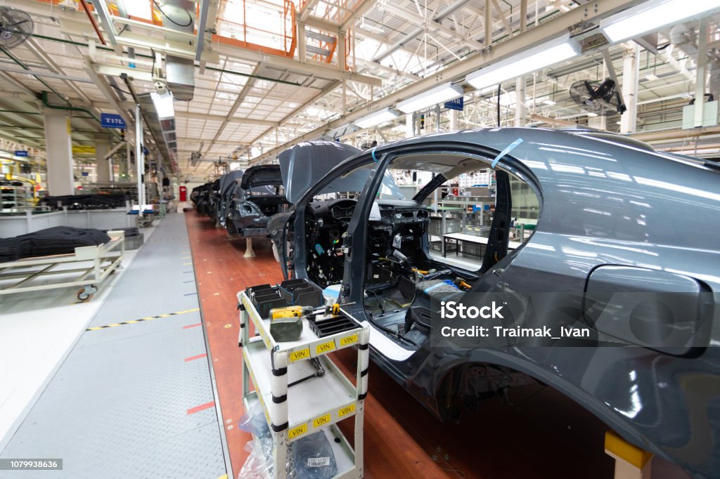 Add details to car body. Robotic equipment makes Assembly of car. Modern car Assembly at factory Automated car Assembly line. The plant of the automotive industry. Line of car body Car Plant Stock Photo