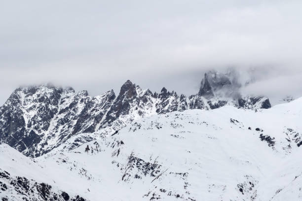istock Rocky mountains in snow and overcast gray sky 1079941126