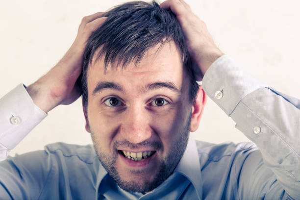 istock desperate young unshaven man in a blue shirt holding his head, he has problems, natural light, a natural guy, natural emotions 1079948816