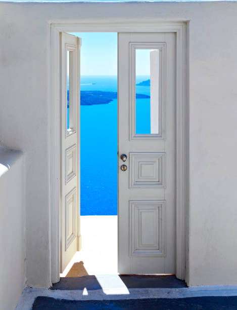 öppna vita dörren med utsikt över havet och calderan, berömda dörr till ingenstans santorini, grekland. - santorini door sea gate bildbanksfoton och bilder