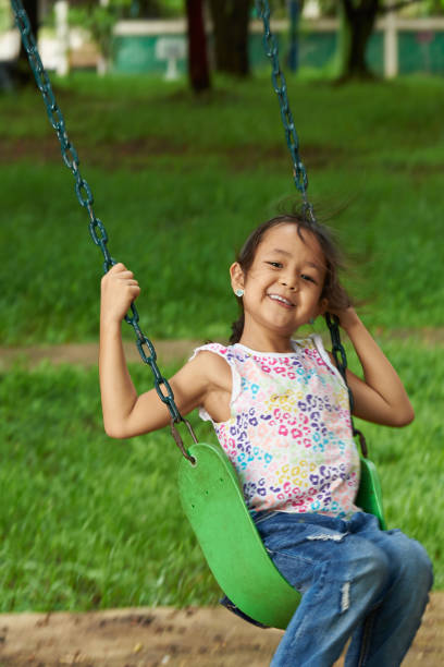 istock Asian girl swinging and smiling 1079982580