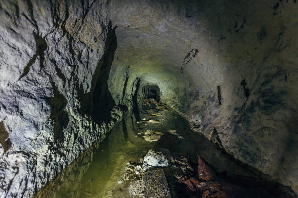 istock Water reflections inside dark dirty flooded abandoned mine 1079995626