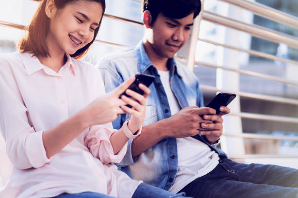 istock Young people are using smartphone and smiling while sitting on free time. technology concept 1080019696
