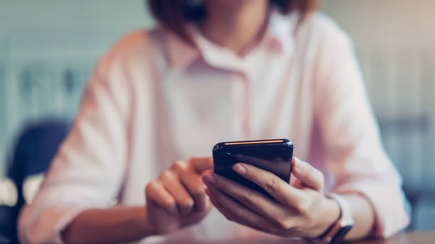 istock woman holding a smartphone, mock up of blank screen. using cell phone on cafe. Technology for communication concept. 1080019792