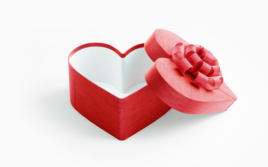 Heart shaped red gift box tied with red ribbon on white background. Horizontal composition with copy space. High angle view. Great use for Christmas and Valentine's Day related gift concepts.