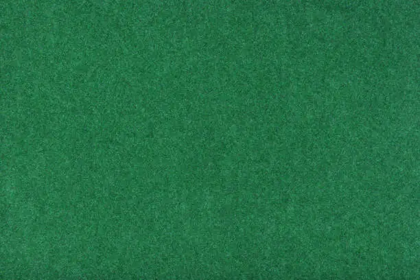 Photo of Light green matt suede fabric closeup. Velvet texture of felt.