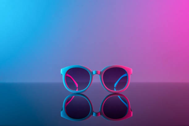 Stylish sunglasses shot using pink and blue abstract colored lighting with copy space. Stylish sunglasses shot using pink and blue abstract colored lighting with copy space. sunglasses photos stock pictures, royalty-free photos & images