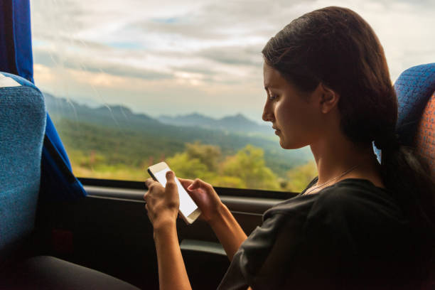 Young woman using mobile phone in the bus. stock photo