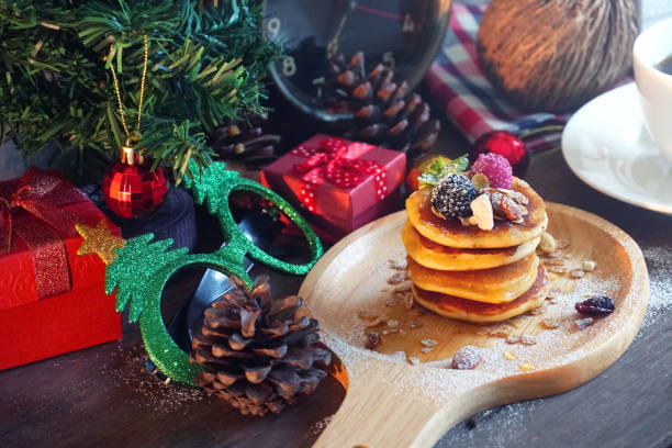 istock Pancake topping with berries and nut with background gift and pine cone under christmas tree, holiday party dessert 1080072998