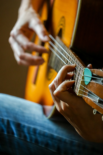 Closeup view of musician playing acoustic guitar.
