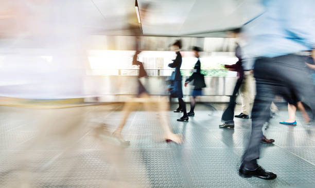 Blurred commuters walking on footbridge Blurred commuters walking on footbridge. elevated walkway photos stock pictures, royalty-free photos & images