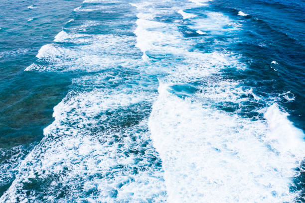 Blue sea waves with a lot of sea foam. Beautiful blue waves with a lot of sea foam scene looked from above, close up