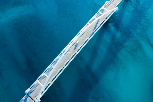 Clear ocean.
Viewpoint from directly above.
The shadow of the bridge appears on the surface of the water.