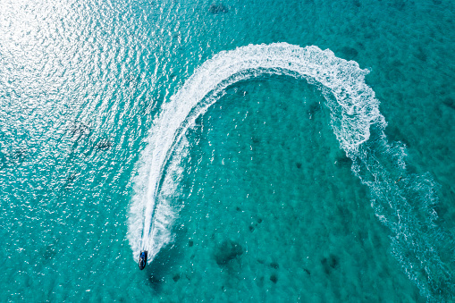 Aerial shooting of clear ocean and jet boat.