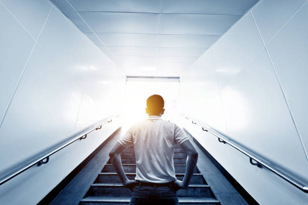 Rear view of man standing at the staircases Rear view of man standing at the staircases. climbing staircase stock pictures, royalty-free photos & images