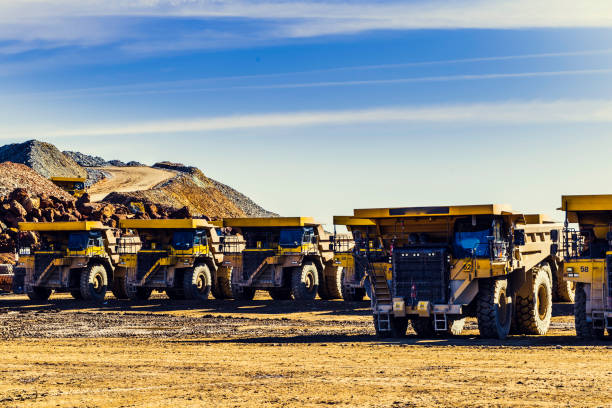 istock Big yellow dumpers put in row in the mine with blue sky 1080112588