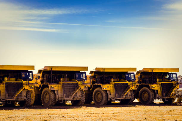 istock Four yellow dump trucks in mine put in row 1080112752