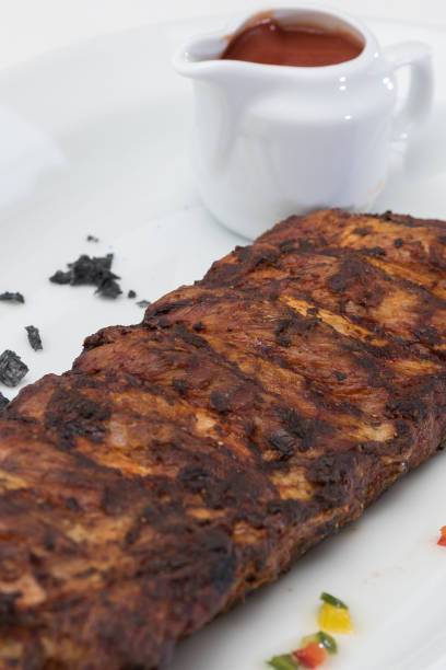 istock Grilled rib pork with barbecue sauce, placed on white plate, light background 1080113068