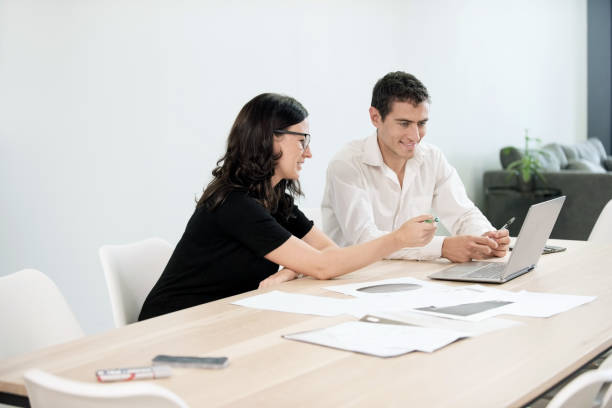 istock Two business colleagues discussing work over a laptop in office. 1080114814