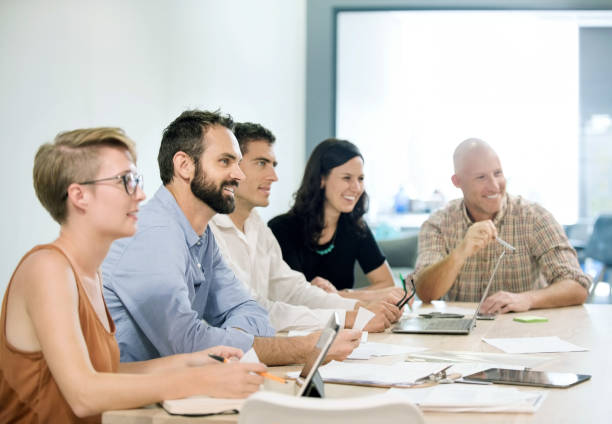 istock Smiling business people watching presentation in board room. 1080114816