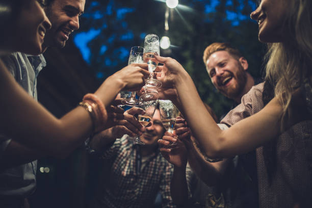 istock Large group of happy people having fun while toasting with alcohol on a night party. 1080115902