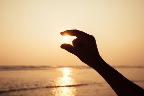 istock Hand fingers caught the sunset shining 1080117060